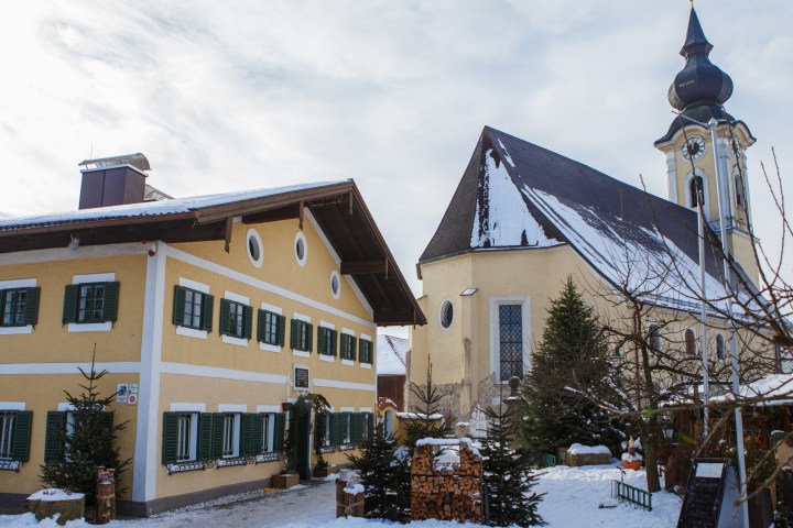 a house covered in snow in front of a building