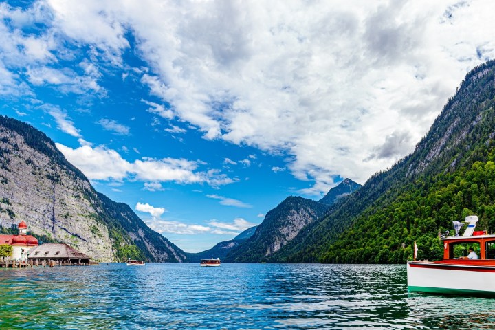 a small boat in a body of water with a mountain in the background