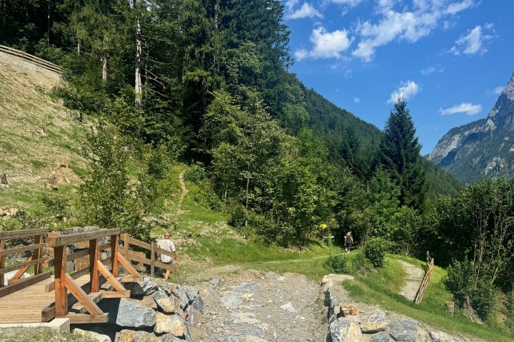 a wooden bench on the side of a mountain