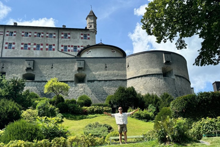 a castle like building with people standing in front of a house