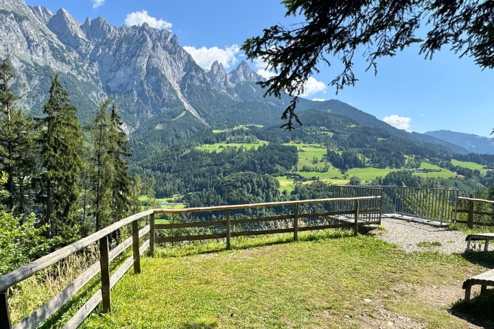 a wooden bench on the side of a mountain