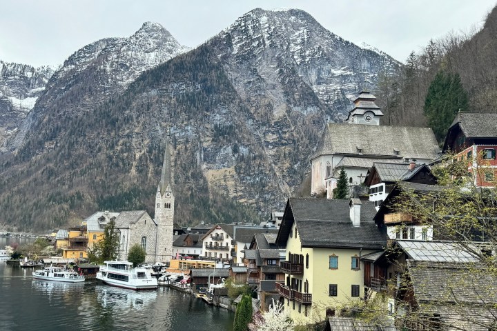 a small boat in a body of water with a mountain in the background