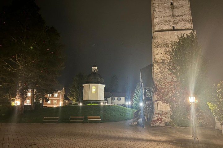 a fountain in front of a building lit up at night