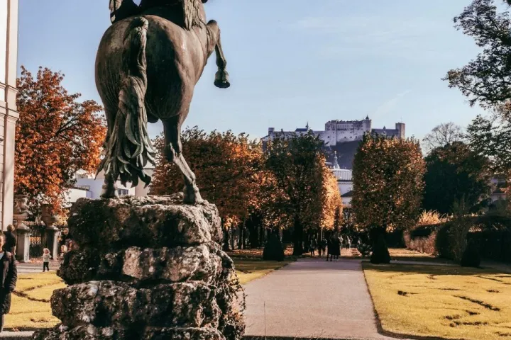 a giraffe standing in front of a large rock