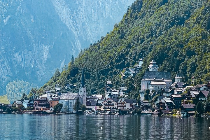 a small boat in a body of water with Hallstatt in the background