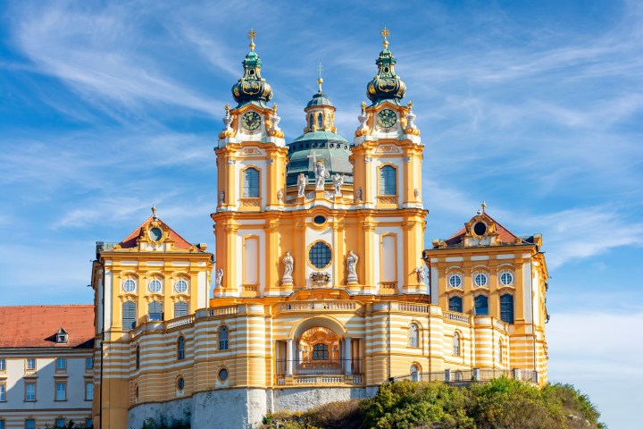 a clock tower in front of Melk Abbey