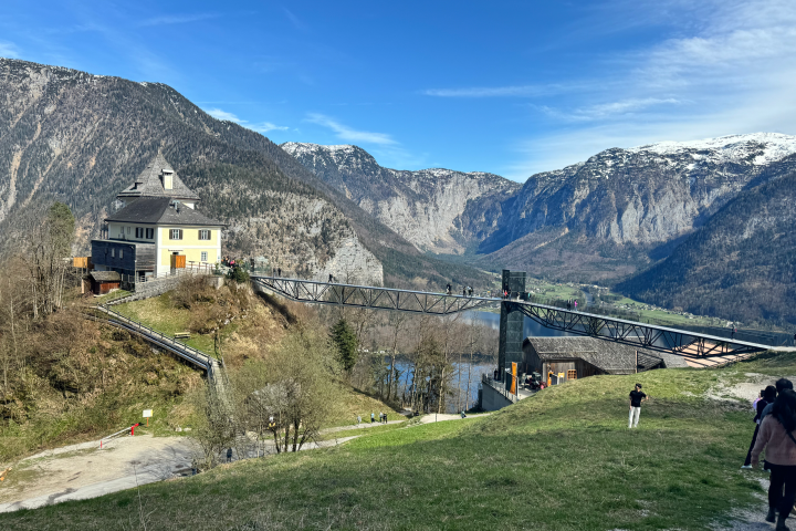 Scenic view of a building and bridge with mountains and clear sky in the background.