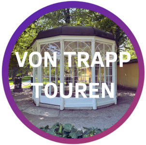 White gazebo with 'Von Trapp Touren' text overlay, surrounded by trees.